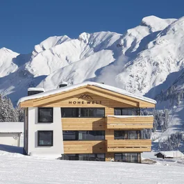 Verschneites Haus Hohe Welt vor einer beeindruckenden Bergkulisse