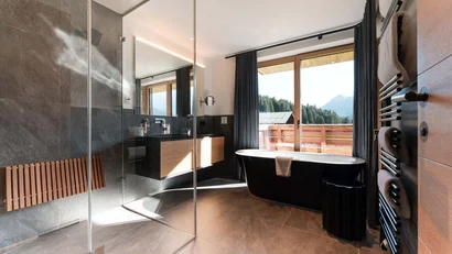 Modernes Badezimmer mit freistehender Badewanne und Bergblick