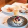 Pfannkuchen mit Beeren und Puderzucker auf einem schwarzen Teller