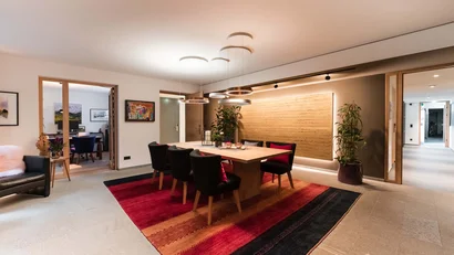 Modernes Esszimmer mit Holztisch, schwarzen Stühlen und rotem Teppich