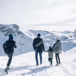 Familie wandert durch verschneite Berglandschaft