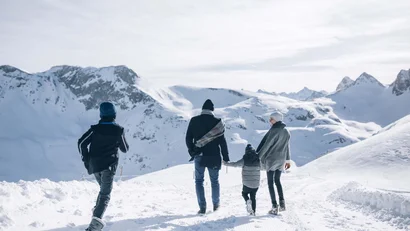 Familie wandert durch verschneite Berglandschaft