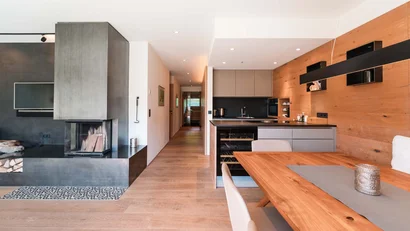 Moderner Wohnbereich mit Kamin, Holzdetails und offener Küche mit Esstisch