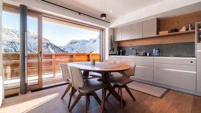 Moderne Küche mit Esstisch und Blick auf verschneite Berge