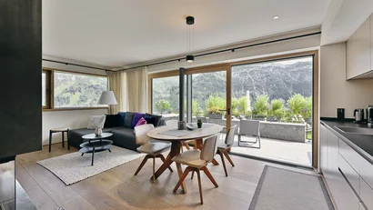 Modernes Wohnzimmer und Essbereich mit Blick auf Berglandschaft