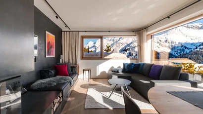 Modernes Wohnzimmer mit Sofas und Panoramablick auf verschneite Berge