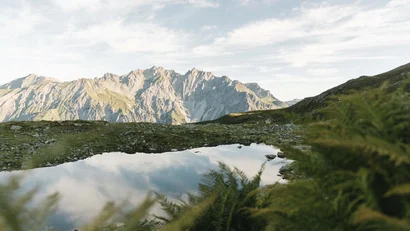 Berglandschaft mit Spiegelung der Wolken in einem kleinen Bergsee